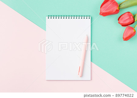 Spiral notepad with pen and flowers. Spiral notepad with pen and flowers. 89774022