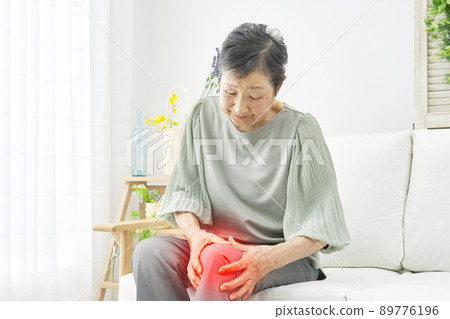 Female elderly knee pain living room Female elderly knee pain living room 89776196
