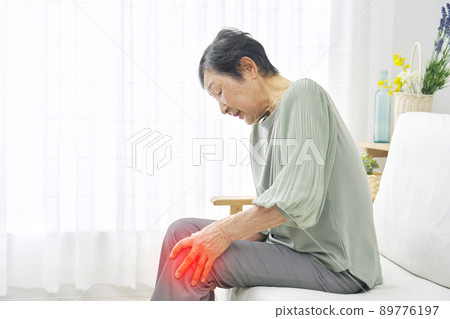 Female elderly knee pain living room 89776197