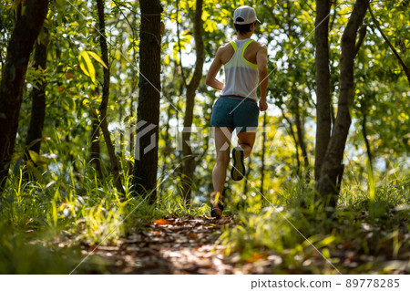 Woman runner running on forest trail Woman runner running on forest trail 89778285