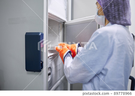 Scientists work in the laboratory. Remove the biomaterial from the freezer 89778966