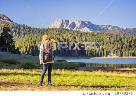 Woman tourist in background of Panoramic morning view of Black Lake Crno Jezero. Calm summer scene of Durmitor Nacionalni Park, Zabljak location, Montenegro, Europe. Beauty of nature concept 89779278