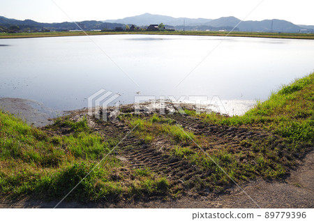 A slope-shaped slope where a farmer enters a paddy field from a farm road ... Yasugi City, Shimane Prefecture: Fine weather 89779396