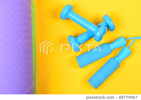 Dumbbells and jump rope in cyan blue color Dumbbells and jump rope in cyan blue color 89779467