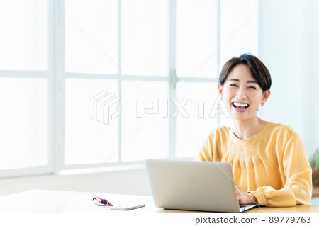 Middle woman using a laptop in the living room 89779763
