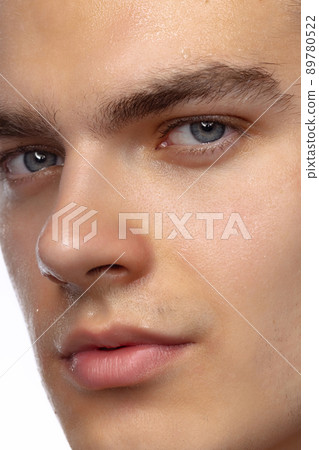 Closeup male blue eyes of young handsome man isolated on white studio background. Concept of men's health, vision, self-care, medicine and cosmetics. 89780522