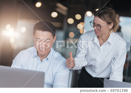 Picture of excited happy emotional colleagues in office working with computer at office Picture of excited happy emotional colleagues in office working with computer at office 89781396