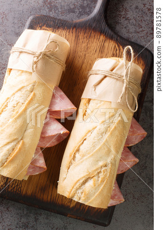 French sandwich crusty baguette, lightly salted butter and thinly sliced ham, ideally Jambon de Paris. Vertical top view 89781578