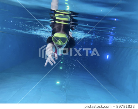 Smiling child in goggles swim, dive in the pool with fun - jump deep down underwater. Healthy lifestyle, people water sport activity on summers.  89781828