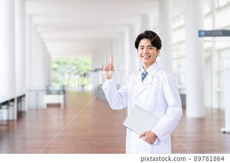 A young man in a lab coat with a computer 89781864