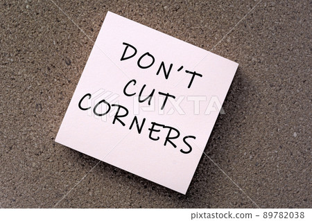 Don't cut corners message on sticky note against brown paper. Don't cut corners message on sticky note against brown paper. 89782038