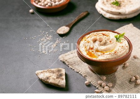 Bowl of homemade hummus on dark background with copyspace. 89782111