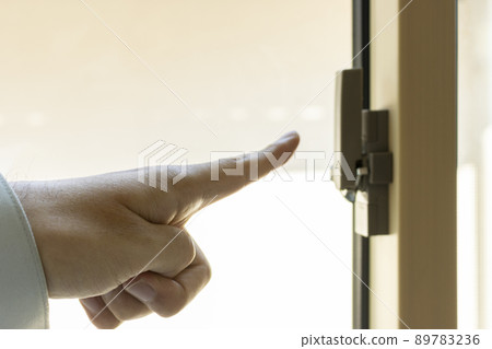 Man's hand checking the window key 89783236