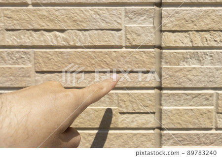 一名男子在外牆上檢查填縫的圖像 89783240