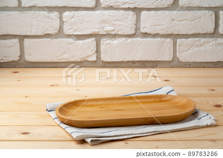 Cutting board with cotton napkin on wooden table 89783286