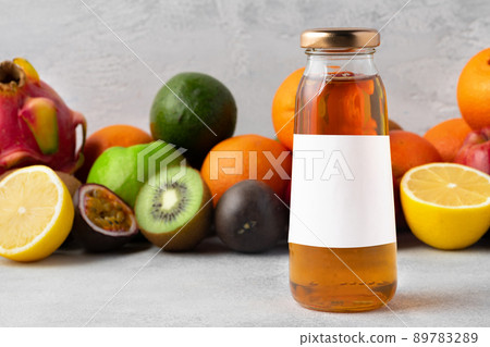 Various fruits and freshly squeezed fruits juice in bottle on gray background 89783289