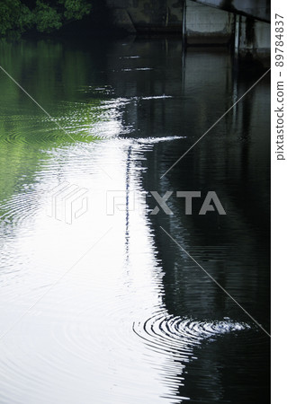 Ripples of water droplets falling from the bridge girder 89784837