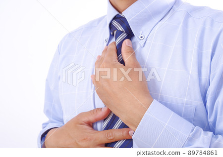 A man tying a tie A man tying a tie 89784861