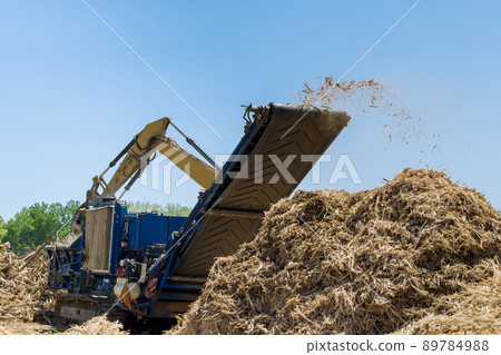 Crane hold roots wood to chipper shredder 89784988