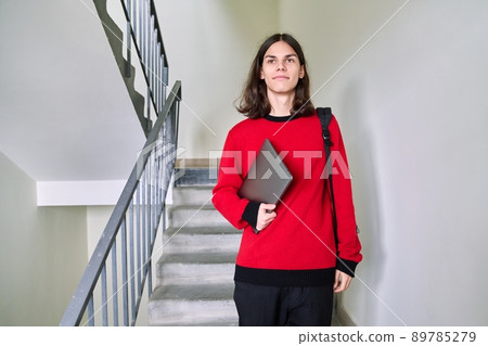 Portrait of teenage student guy with laptop backpack, looking at camera 89785279