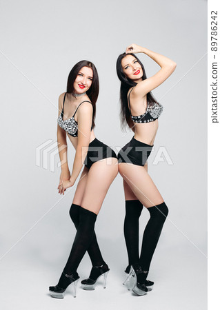Two sexy twins in pole dancers costumes. 89786242