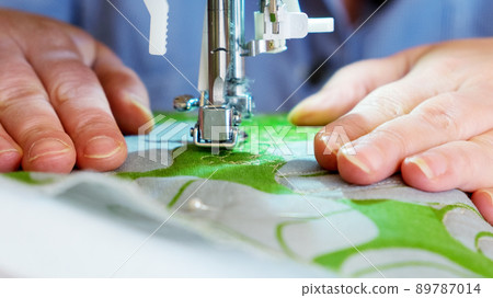 Part of a sewing machine and a woman's hands close-up 89787014
