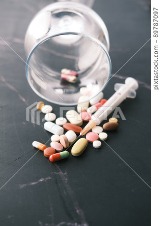 wine glass, syringe and pills on dark background, close up wine glass, syringe and pills on dark background, close up 89787097