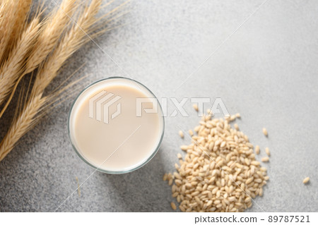 Vegan Barley milk in glass, plant based milk replacer. 89787521