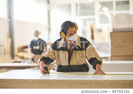 Craftsperson examining wooden material before production 89788182