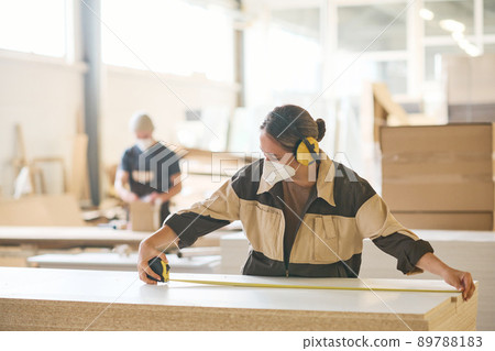 Female worker using tape measure at work 89788183