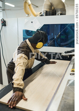 Worker working on machine for sawing wood Worker working on machine for sawing wood 89788193