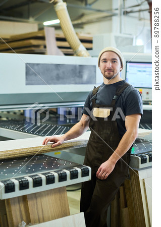 Carpenter working with wood at plant 89788256