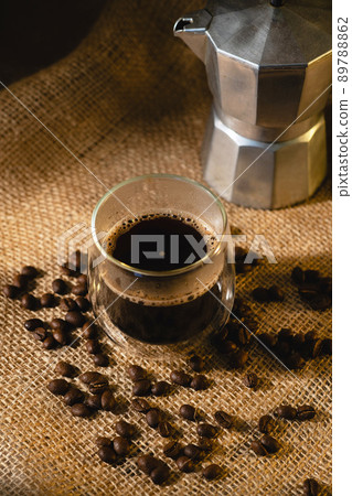 View from above of a coffee cup and a geyser coffee maker on a dark background. View from above of a coffee cup and a geyser coffee maker on a dark background. 89788862