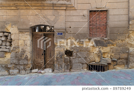 Grunge stone bricks wall with Broken wooden door and closed broken window, Cairo, Egypt 89789249