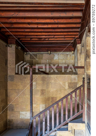 Staircase with wooden balustrade leading to an old abandoned historic building 89789272