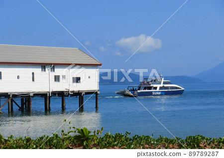 Pleasure boat running over the sea across a white building 89789287