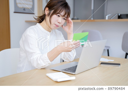 A woman who looks at her passbook and thinks about it 89790484