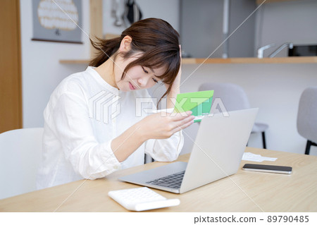 A woman who looks at her passbook and thinks about it 89790485