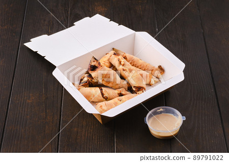 Slices of pear rolled in dough with caramel sauce in take away package Slices of pear rolled in dough with caramel sauce in take away package 89791022