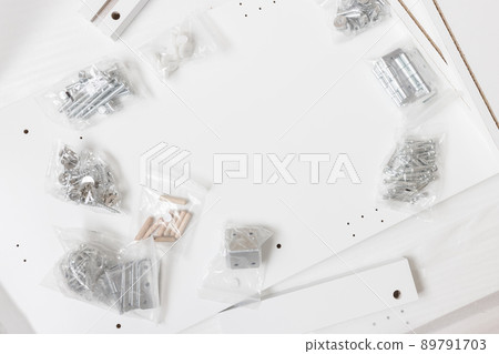 Box with furniture assembly parts on the floor Box with furniture assembly parts on the floor 89791703