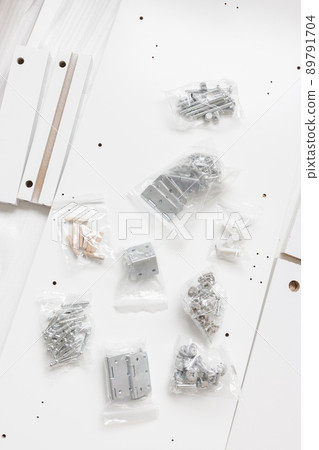 Box with furniture assembly parts on the floor Box with furniture assembly parts on the floor 89791704