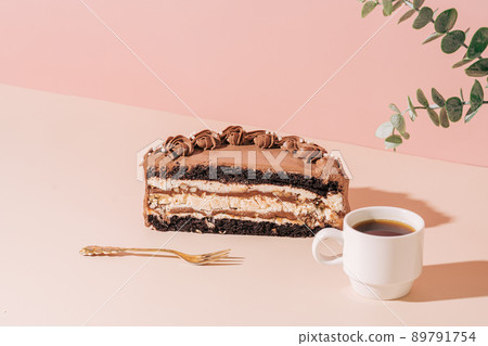 Half of sliced cake next to fork and cup of coffee on pink background Half of sliced cake next to fork and cup of coffee on pink background 89791754