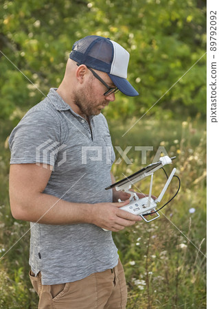 Man manages quadrocopters. Remote control for the drone in the hands of men. Unmanned aerial vehicle 89792092