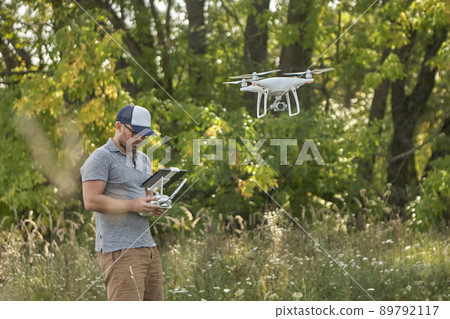 Man manages quadrocopters. Remote control for the drone in the hands of men. Unmanned aerial vehicle Man manages quadrocopters. Remote control for the drone in the hands of men. Unmanned aerial vehicle 89792117