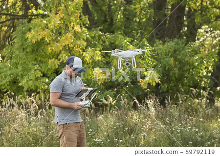 Man manages quadrocopters. Remote control for the drone in the hands of men. Unmanned aerial vehicle Man manages quadrocopters. Remote control for the drone in the hands of men. Unmanned aerial vehicle 89792119