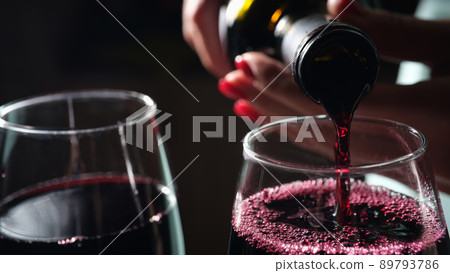 Woman pouring red wine into glass, tasting and degustation Woman pouring red wine into glass, tasting and degustation 89793786
