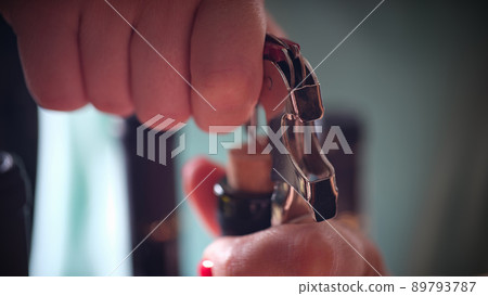 Woman opening bottle of wine with corkscrew Woman opening bottle of wine with corkscrew 89793787