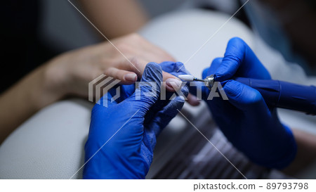 Manicurist doing manicure to client using special apparatus 89793798