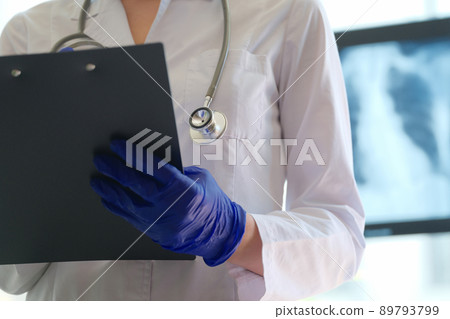 Doctor with clipboard filling form of patient Doctor with clipboard filling form of patient 89793799
