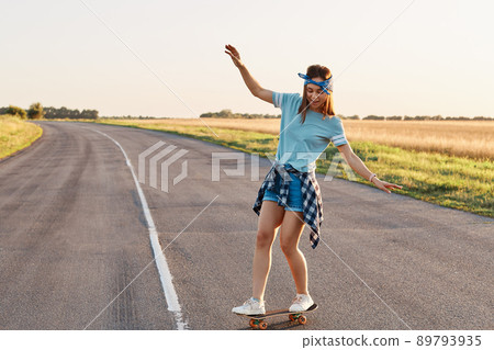 Sporty woman riding on the skateboard on the road., Slim sporty female enjoying longboarding, raising hands , having happy concentrated expression, healthy lifestyle, copy space. Sporty woman riding on the skateboard on the road., Slim sporty female enjoying longboarding, raising hands , having happy concentrated expression, healthy lifestyle, copy space. 89793935